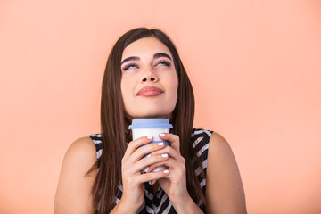 Coffee lover concept. Closeup photo portrait of delightful cheerful positive with toothy beaming smile person holding cup of warm latte in hands cuddling to herself isolated bright color background