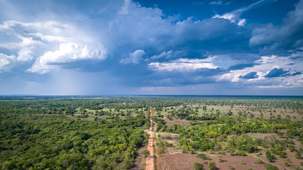 Aerial view of Transpantaneira dirt road with dramatic sky and rain crossing the typical landscape in North Pantanal Wetlands, Mato Grosso, Brazil