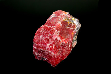 macro mineral Rhodonite stone on a black background
