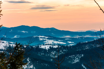 Winter tranquil stretched mountain landscape and the Carpathian mountain range behind.