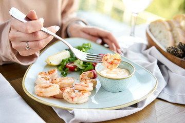 Grilled Argentine shrimp with mango-jalapeno sauce. Lunch in a restaurant, a woman eats delicious...