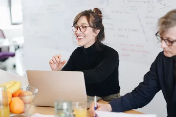 Candid portrait of beautiful female marketing expert working on new ideas within creative team during a meeting in office. © mlasaimages