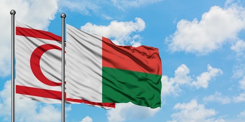 Northern Cyprus and Madagascar flag waving in the wind against white cloudy blue sky together. Diplomacy concept, international relations.