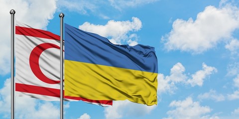 Northern Cyprus and Ukraine flag waving in the wind against white cloudy blue sky together. Diplomacy concept, international relations.
