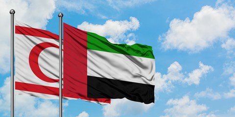 Northern Cyprus and United Arab Emirates flag waving in the wind against white cloudy blue sky together. Diplomacy concept, international relations.