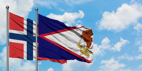 Norway and American Samoa flag waving in the wind against white cloudy blue sky together. Diplomacy concept, international relations.