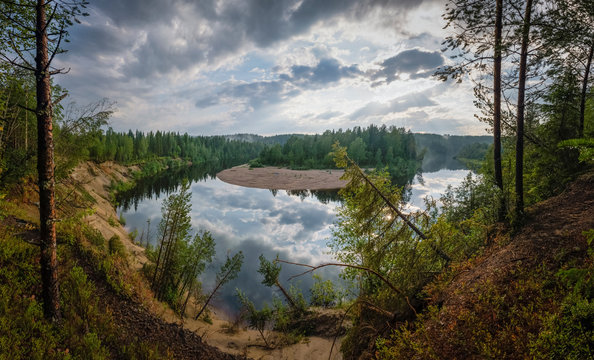 Panorama of the beautiful and still Orealven river in Sweden with beautiful reflection of the clouded sky