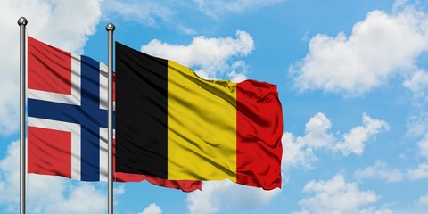 Norway and Belgium flag waving in the wind against white cloudy blue sky together. Diplomacy concept, international relations.