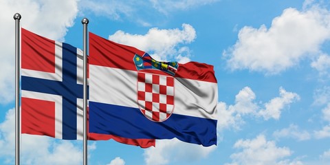 Norway and Croatia flag waving in the wind against white cloudy blue sky together. Diplomacy...