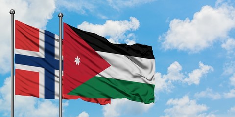 Norway and Jordan flag waving in the wind against white cloudy blue sky together. Diplomacy...