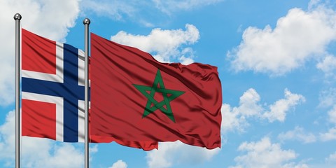 Norway and Morocco flag waving in the wind against white cloudy blue sky together. Diplomacy concept, international relations.