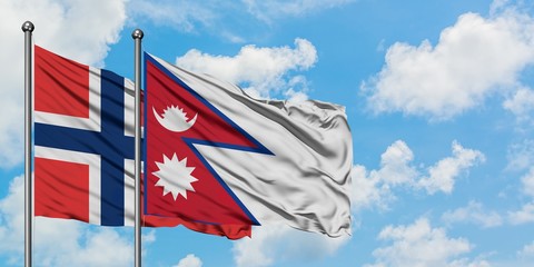 Norway and Nepal flag waving in the wind against white cloudy blue sky together. Diplomacy concept, international relations.