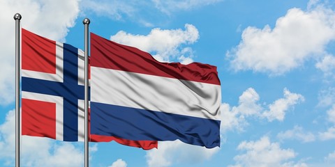 Norway and Netherlands flag waving in the wind against white cloudy blue sky together. Diplomacy...