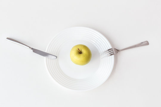 Be on Diet. Apple on plate isolated on kitchen table top view close-up