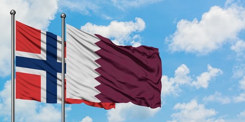 Norway and Qatar flag waving in the wind against white cloudy blue sky together. Diplomacy concept, international relations.