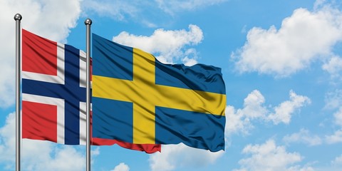 Norway and Sweden flag waving in the wind against white cloudy blue sky together. Diplomacy concept, international relations.