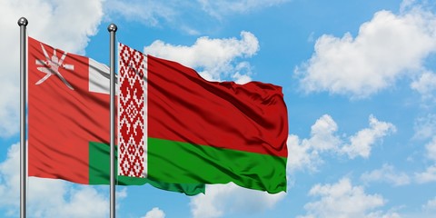 Oman and Belarus flag waving in the wind against white cloudy blue sky together. Diplomacy concept,...