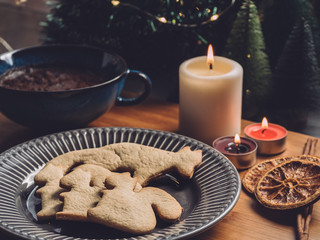 homemade christmas cookies and a chocolate cup, cinnamon, spice, candles and christmas tree on background. Cosy atmosphere 2
