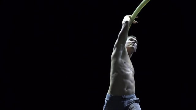 Muscular circus artist in the Cyr Wheel doing difficult tricks slow motion. Concept of concentration and balance