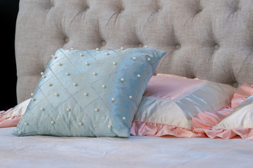 Modern blue with pearl and pink fabric pillows on brown fabric cushion bed interior decoration