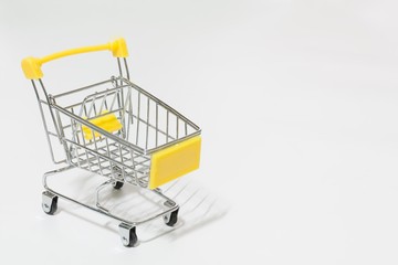 Empty yellow shopping cart isolated on white background