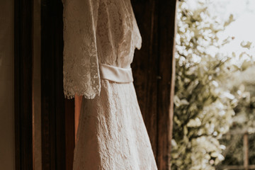 Bride's Wedding Dress Hanging in Victorian Doorway