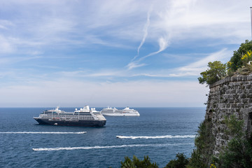 Two cruise ships at sea during sunny day surrounded by lots of powerboats. Monte Carlo, Monaco.