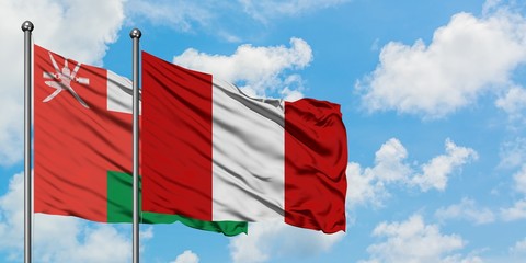 Oman and Peru flag waving in the wind against white cloudy blue sky together. Diplomacy concept, international relations.