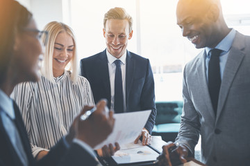 Diverse businesspeople smiling while meeting together around an