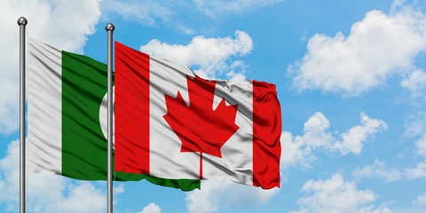Pakistan and Canada flag waving in the wind against white cloudy blue sky together. Diplomacy concept, international relations.