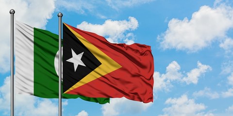 Pakistan and East Timor flag waving in the wind against white cloudy blue sky together. Diplomacy...