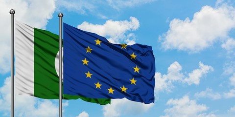 Pakistan and European Union flag waving in the wind against white cloudy blue sky together....
