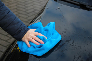 Cleaning a car with a blue sponge