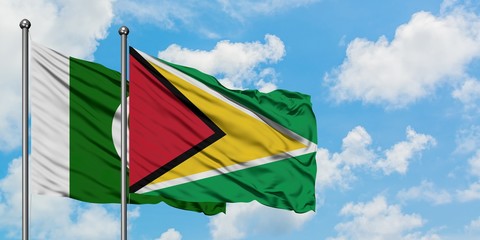 Pakistan and Guyana flag waving in the wind against white cloudy blue sky together. Diplomacy concept, international relations.