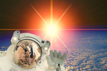 Astronaut and sunrise. The elements of this image furnished by NASA.
