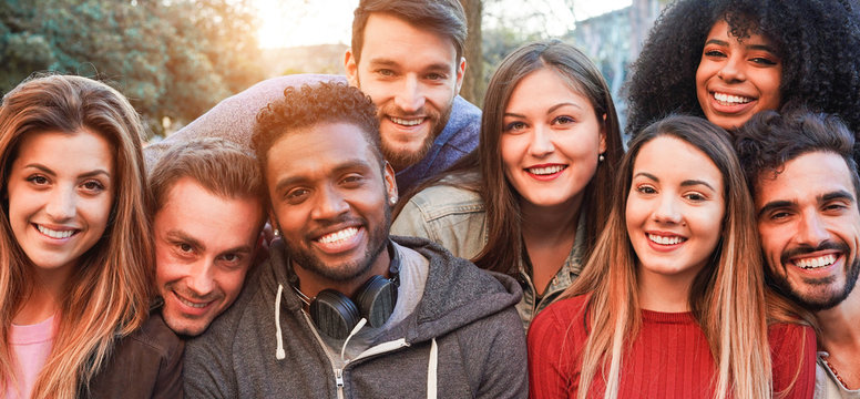 Happy millennial friends from diverse cultures and races having fun posing in front of smartphone camera - Youth and friendship concept - Young multiracial people smiling - Main focus on african man