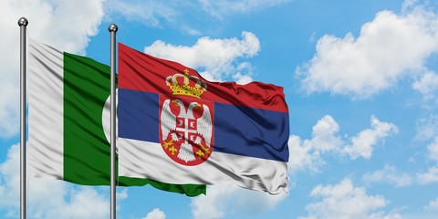 Pakistan and Serbia flag waving in the wind against white cloudy blue sky together. Diplomacy...