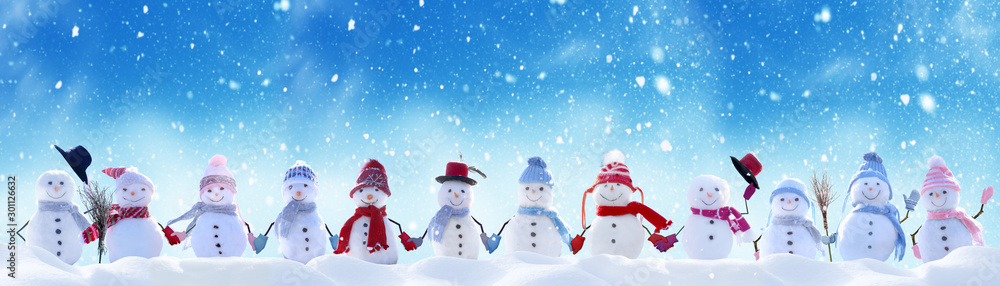 Wall mural Merry Christmas and happy New Year greeting card with copy-space.Many snowmen standing in winter Christmas landscape.Winter background