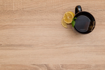 A mug of tea and lemons on a wooden table