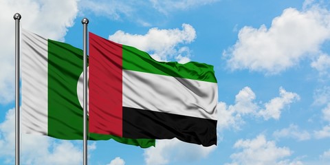 Pakistan and United Arab Emirates flag waving in the wind against white cloudy blue sky together. Diplomacy concept, international relations.