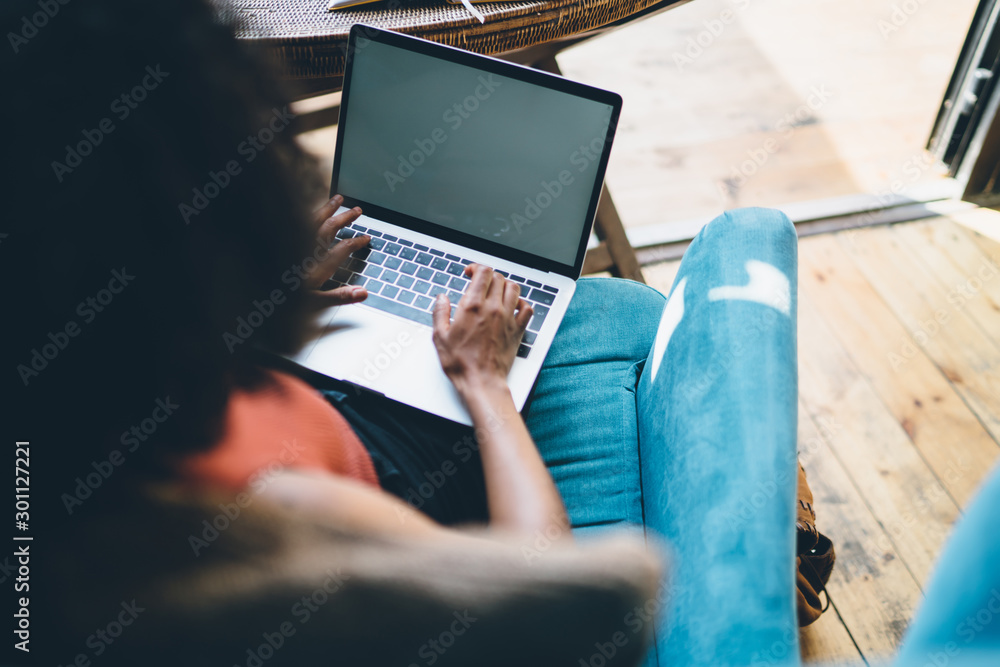Poster back view of millennial woman copywriter working remotely with content article using 4g wireless int