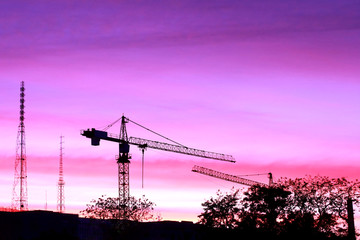 silhouette of construction site at sunset in evening time,project building construction in urban with cranes