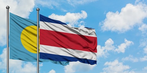 Palau and Costa Rica flag waving in the wind against white cloudy blue sky together. Diplomacy concept, international relations.