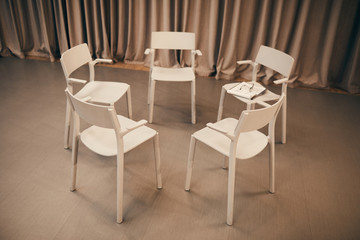 Image of white chairs standing in circle in the room they prepared for the meeting