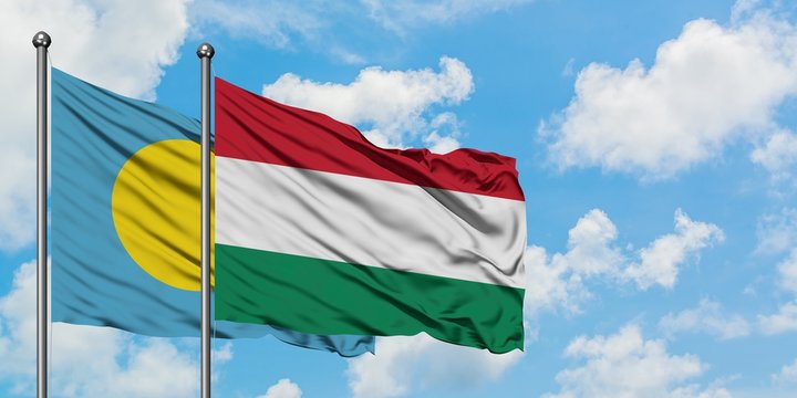 Palau and Hungary flag waving in the wind against white cloudy blue sky together. Diplomacy concept, international relations.