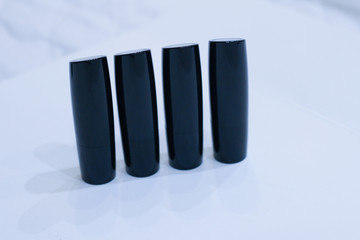 tubes of black lipsticks on a white background