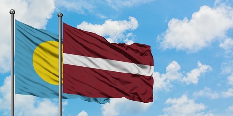 Palau and Latvia flag waving in the wind against white cloudy blue sky together. Diplomacy concept, international relations.