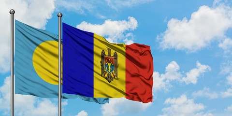 Palau and Moldova flag waving in the wind against white cloudy blue sky together. Diplomacy concept, international relations.