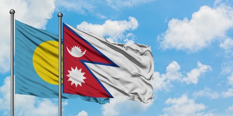 Palau and Nepal flag waving in the wind against white cloudy blue sky together. Diplomacy concept, international relations.