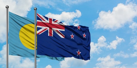 Palau and New Zealand flag waving in the wind against white cloudy blue sky together. Diplomacy...